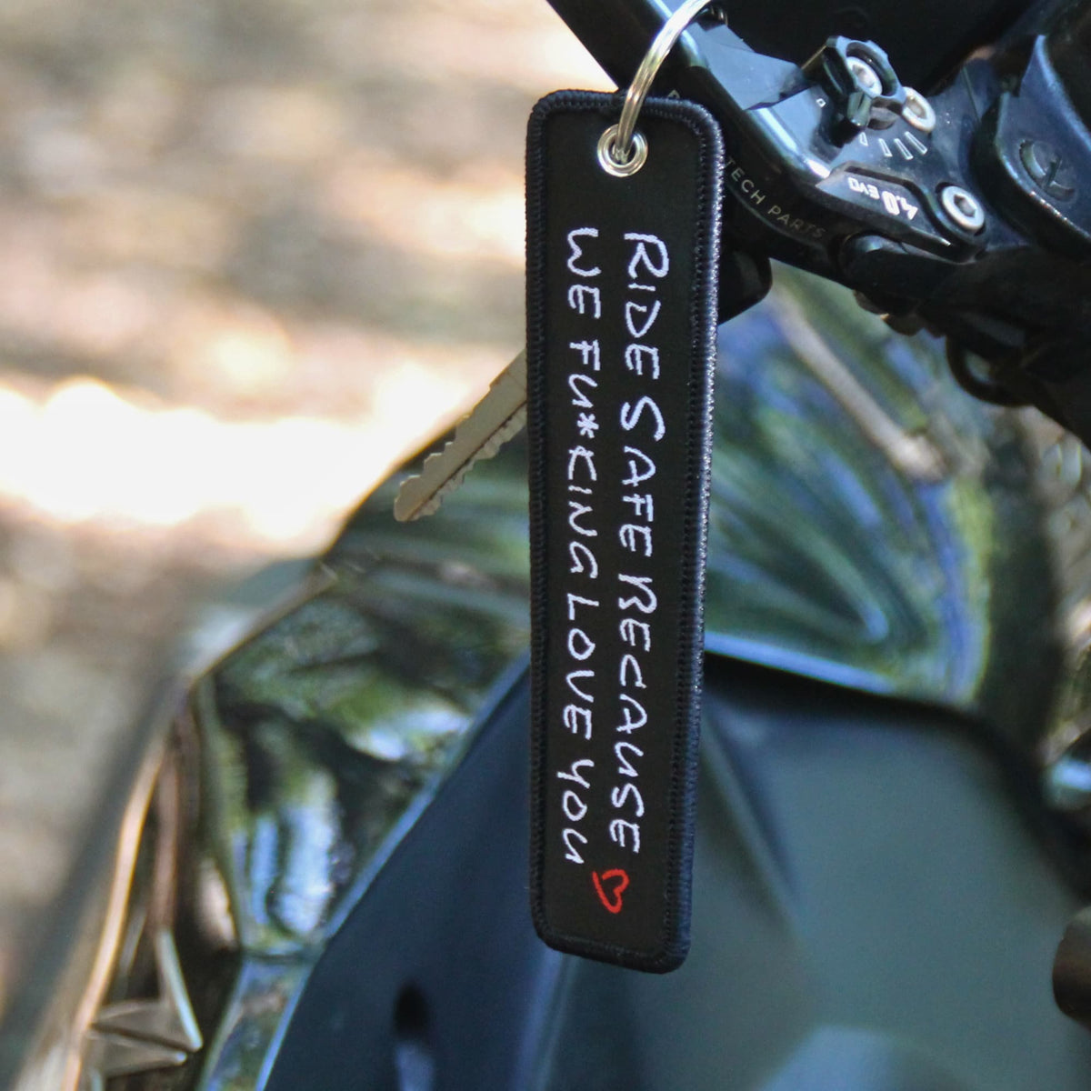 Porte clé moto tissu brodé avec texte "Ride safe because we fu*king love you"