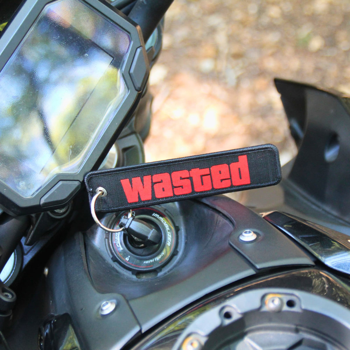 Porte clé moto en tissu brodé rouge sur noir de l'inscription WASTED ("éliminé") inspiré de l'univers gaming.