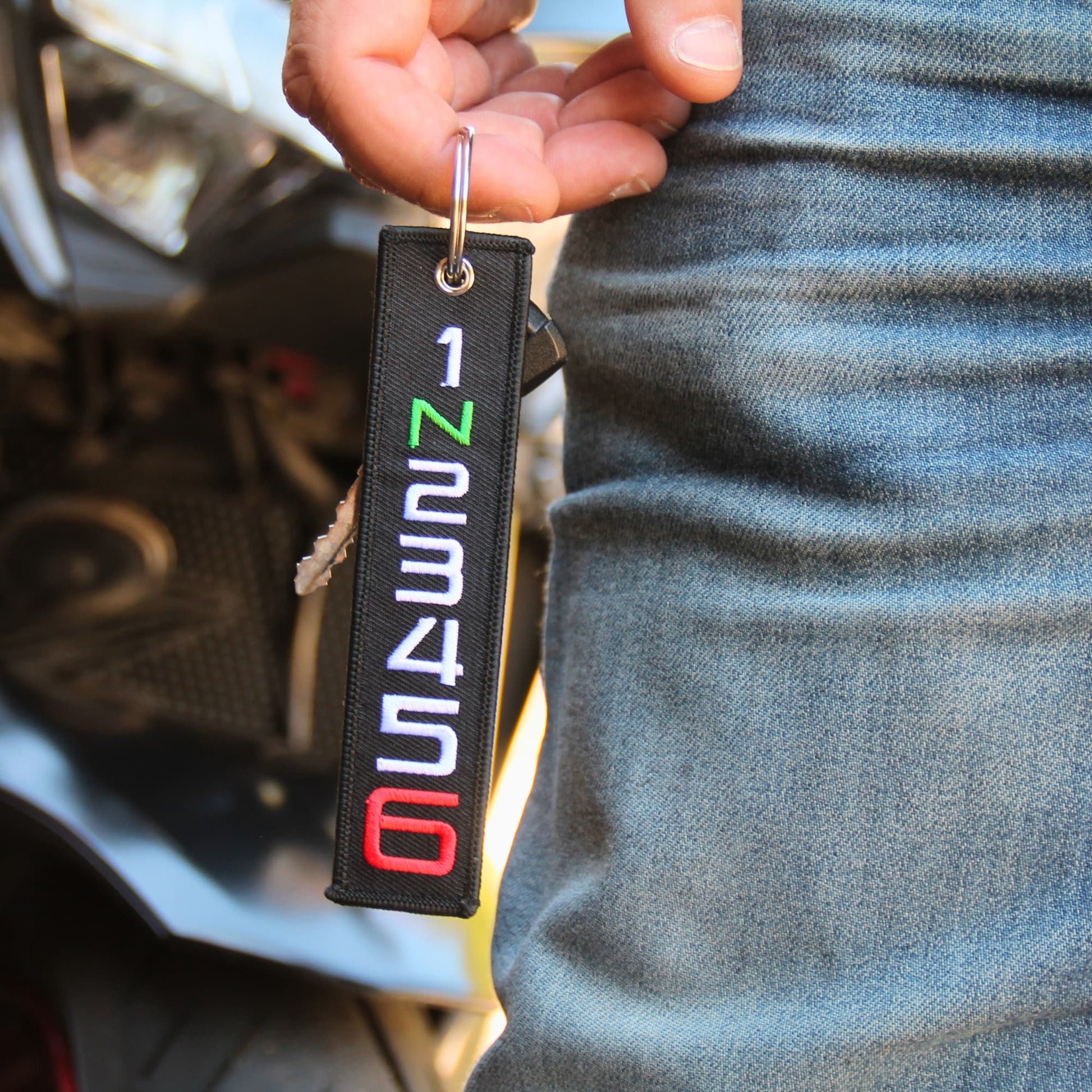 Porte clé motard tissu 1 N 2 3 4 5 6 tenu en main