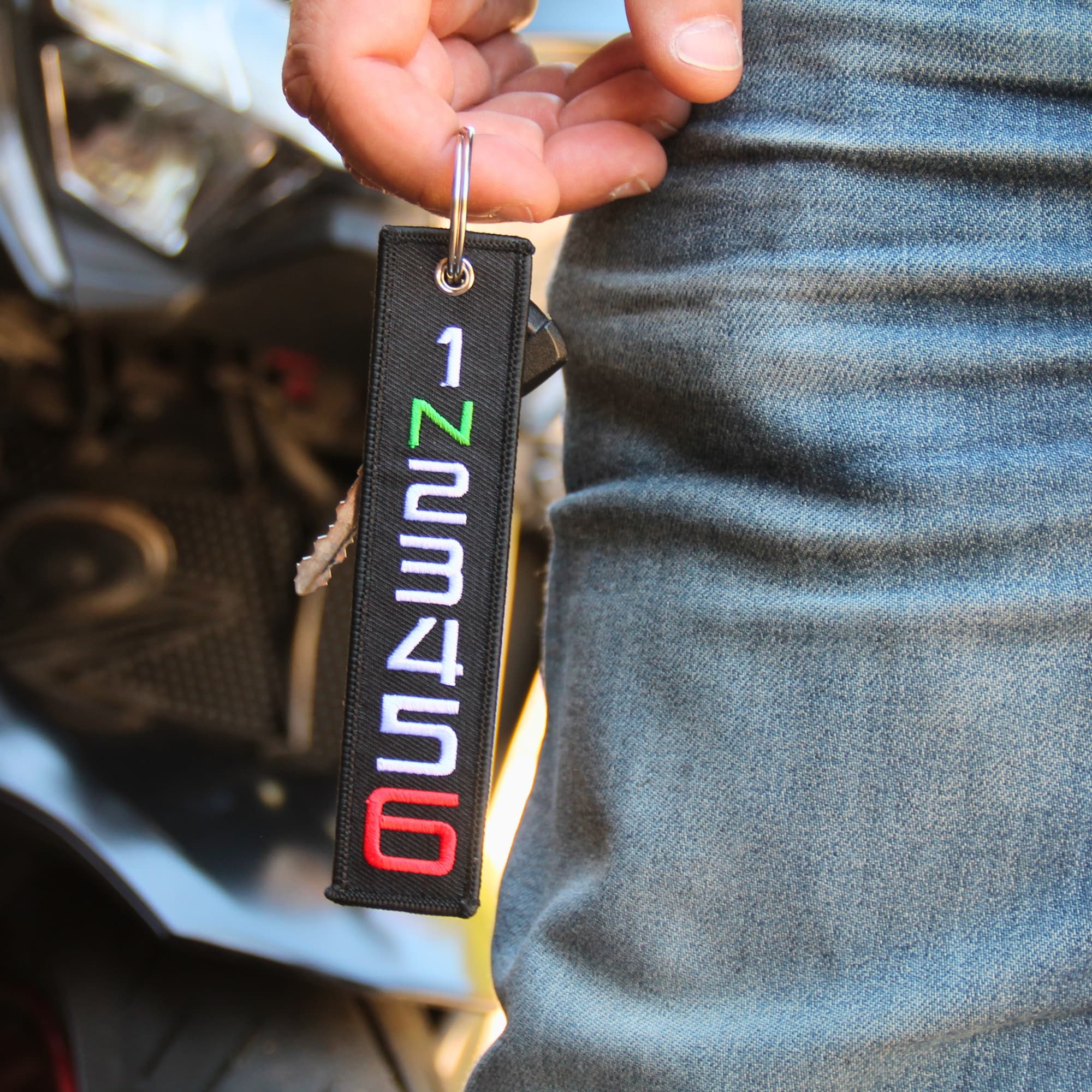 Porte clé motard tissu 1 N 2 3 4 5 6 tenu en main