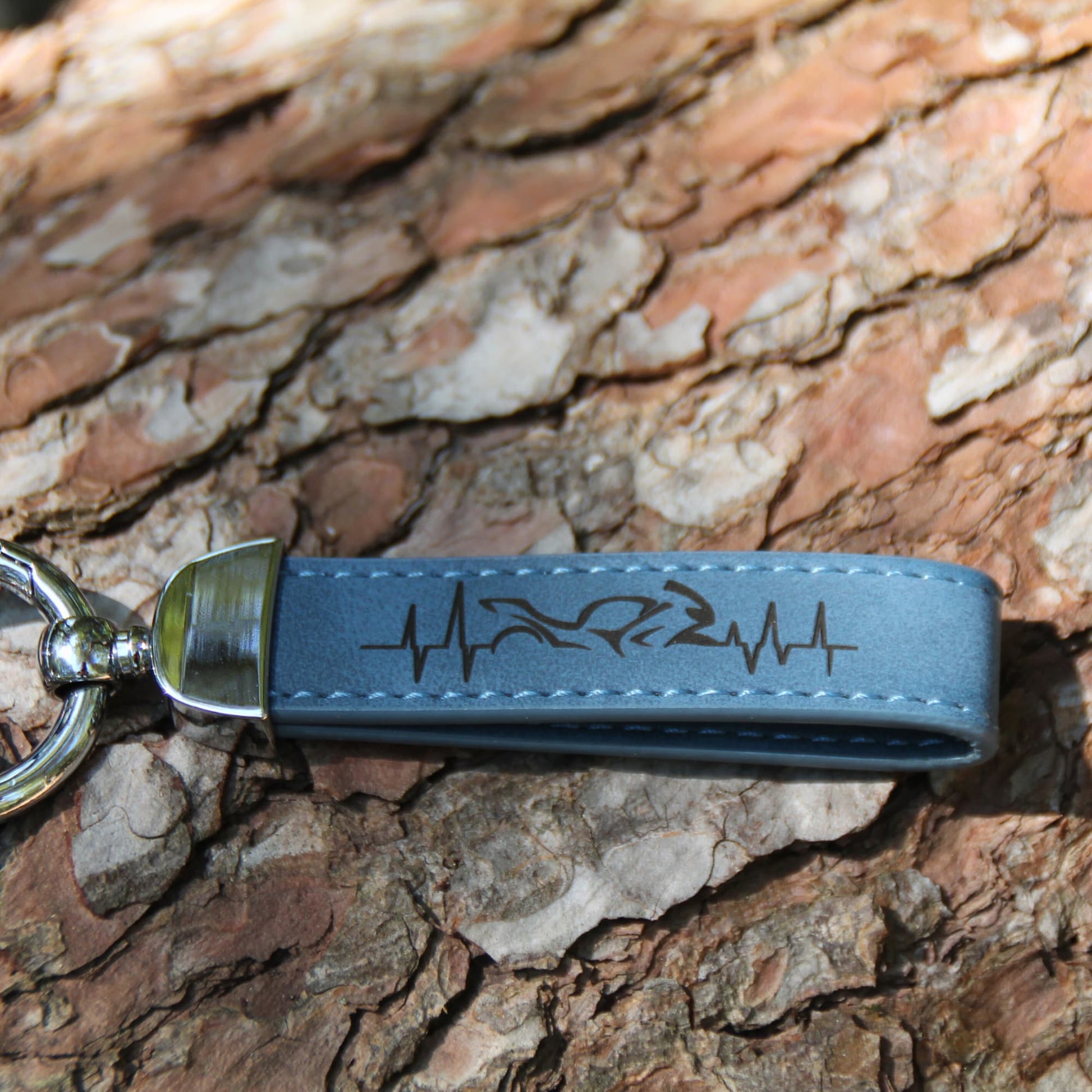 Porte clé en simili cuir bleu gravé d'une ligne de vie traversant une moto. Idée cadeau originale pour passionné de moto !