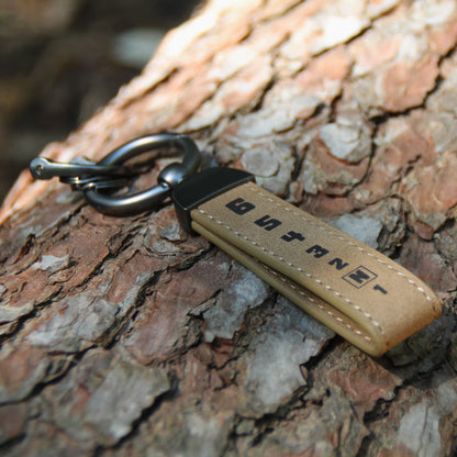 Porte clés en simili cuir marron gravé 1N23456, symbolisant les vitesses sur une moto. 