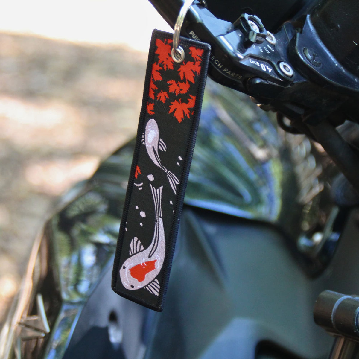 Porte clé en tissu brodé de carpes koi et feuilles d'érable, face verso. 