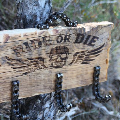 Détail de la gravure Ride or Die avec tête de mort ailée sur porte-clé mural en bois style biker
