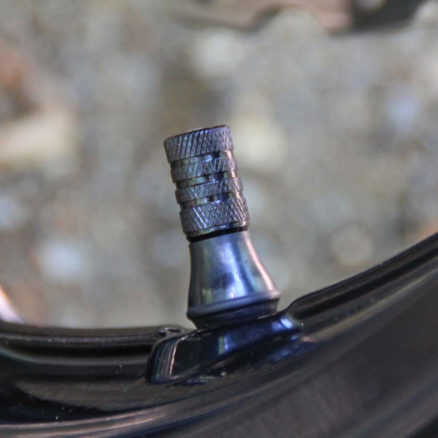 Vue de profile des bouchons de valve moto noirs et crâne blanc vendus par deux. 