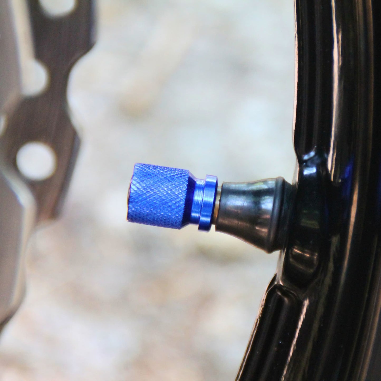 Zoom sur le profile des bouchons de valve moto bleus et rose des vents.