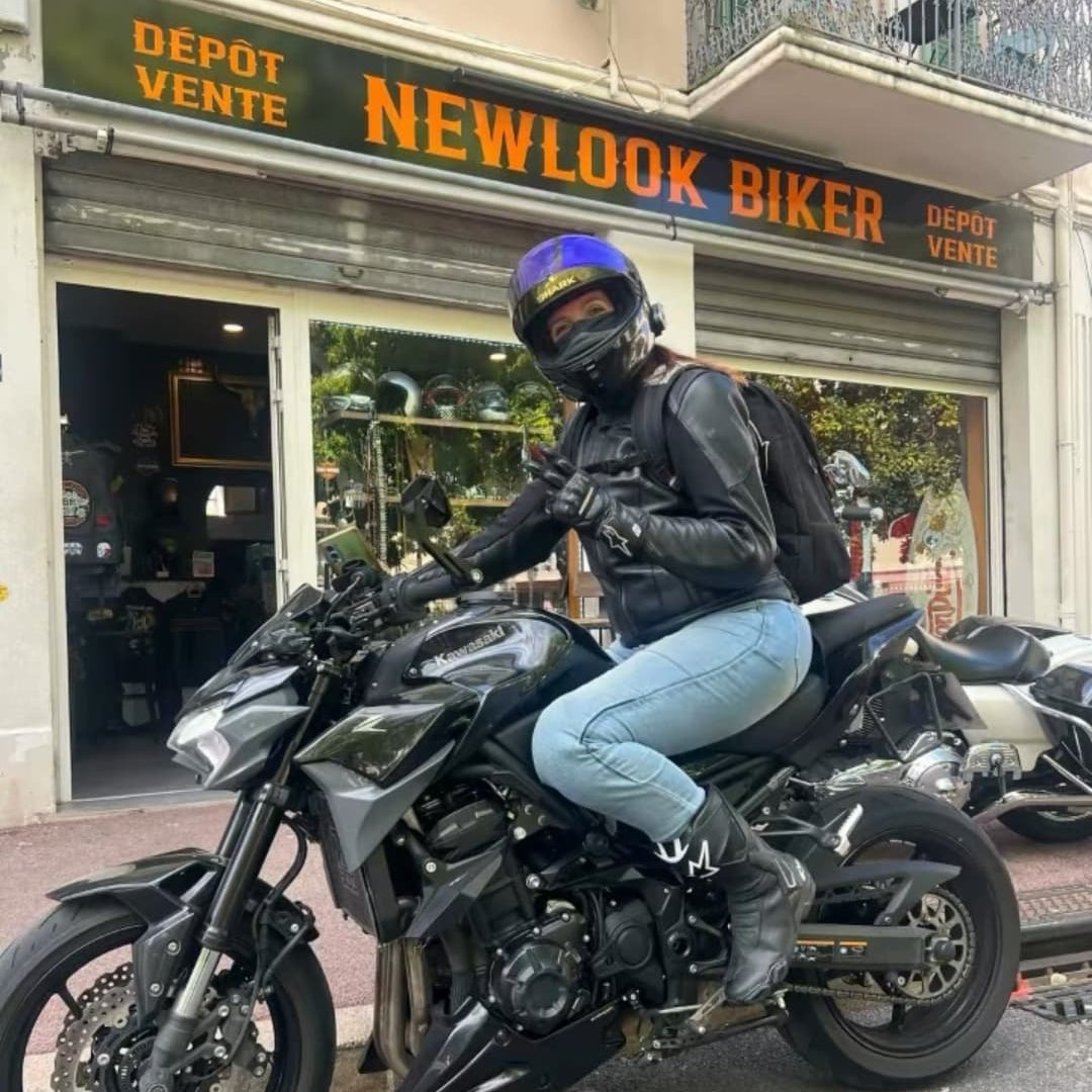 Débora, gérante de secrets de bikers, sur sa kawasaki z900 devant la boutique New Look Biker