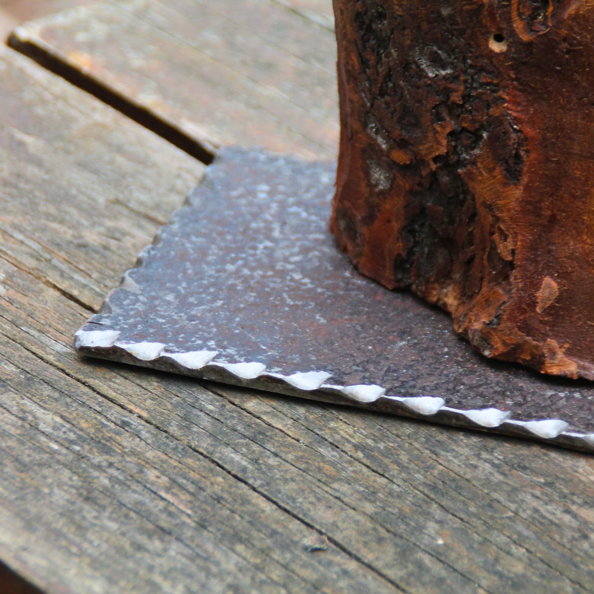 Zoom sur le socle en métal de la belle horloge en bois fruitier