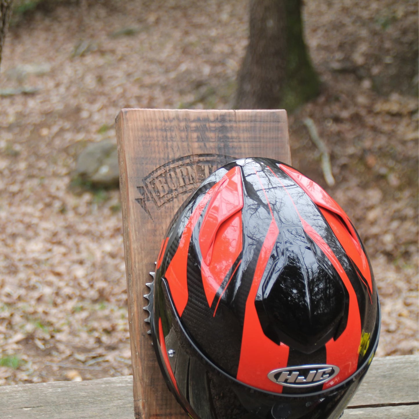 Mise en situation du support de casque moto duo en bois et pièces mécaniques recyclées. 