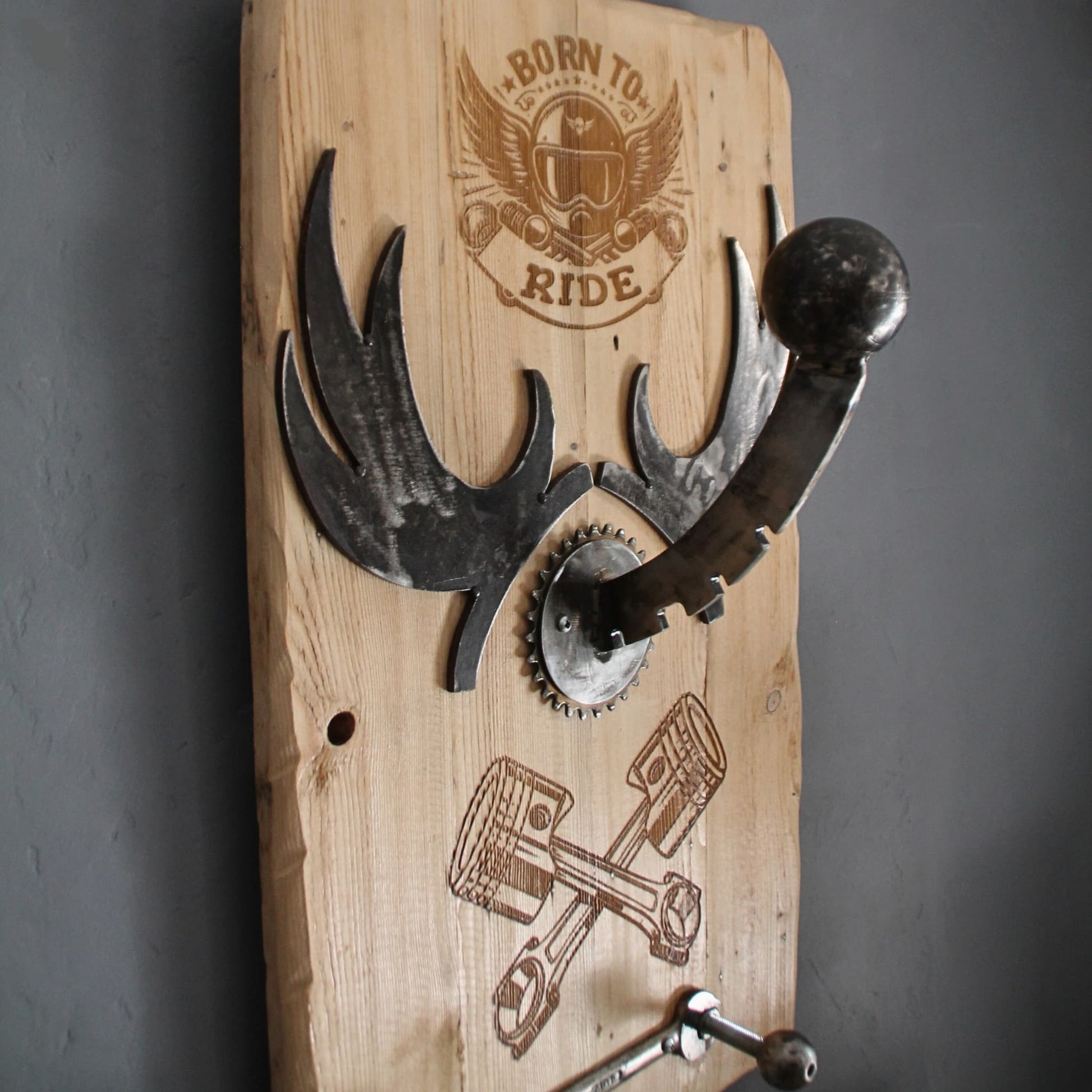 Vue générale du support de casque moto gravé avec "Born to Ride" et pistons, fabriqué à partir de bois recyclé et pièces métalliques, avec un design robuste et unique.