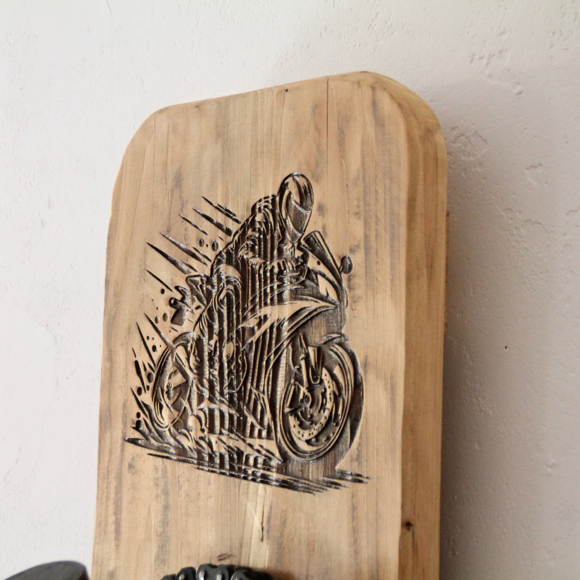 Gravure laser d'une silhouette de pilote sur sa moto sur le support casque bois.