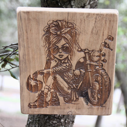 Tableau artisanal en bois gravé d'une motarde caricaturale. Fait main en france