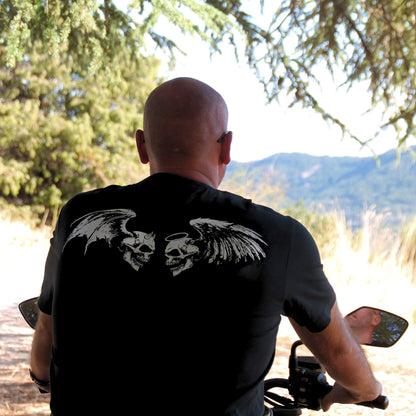 Détails sur le dessin au dos du T-shirt biker en coton. Deux têtes de mort se font face, l'une avec aile et cornes de démon, l'autre avec auréole et ailes d'ange. 