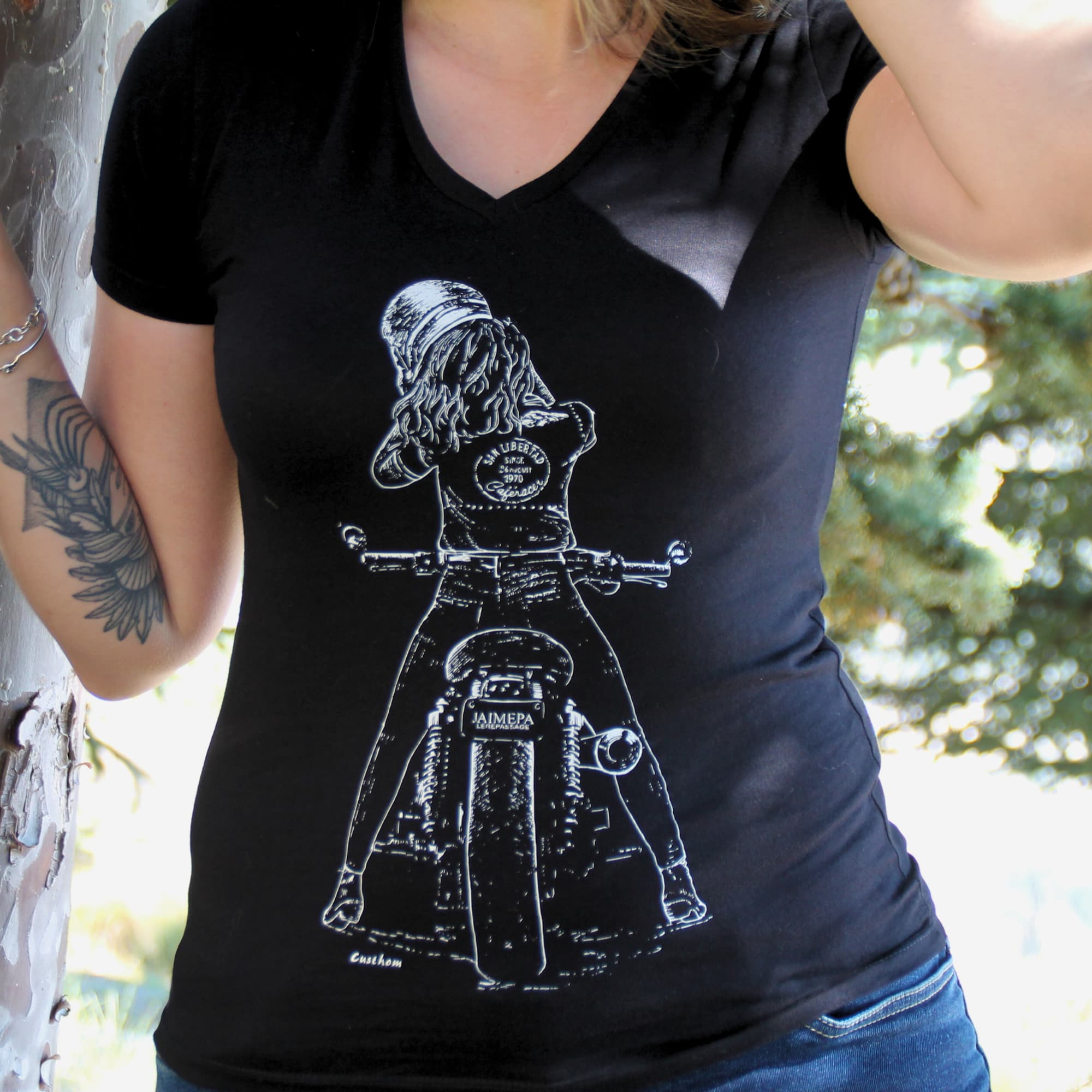 T-shirt femme en coton noir avec une illustration d’une motarde retirant son casque. L'inscription "j'aime pas le repassage" sur la plaque donne un trait d'humour à ce t-shirt. Parfait pour les passionnées de moto et de liberté sur deux roues.