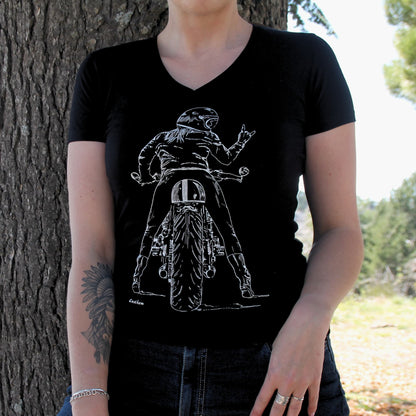 T-shirt féminin en coton premium (190g), avec un design original d’une motarde vue de dos sur sa moto, faisant un signe rock. Confortable, résistant et stylé, pour un look audacieux.