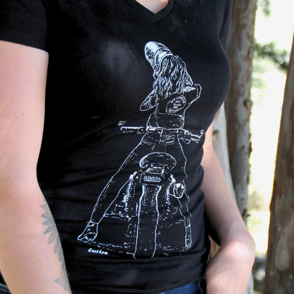 T-shirt féminin en coton noir avec une illustration élégante d’une motarde en pleine action, retirant son casque. Un design parfait pour les amoureuses de moto.