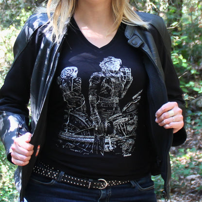 T-shirt col V 100% coton pour femme, porté sous une veste en cuir, avec une motarde prenant une pause café sur sa moto lors de son roadtrip.