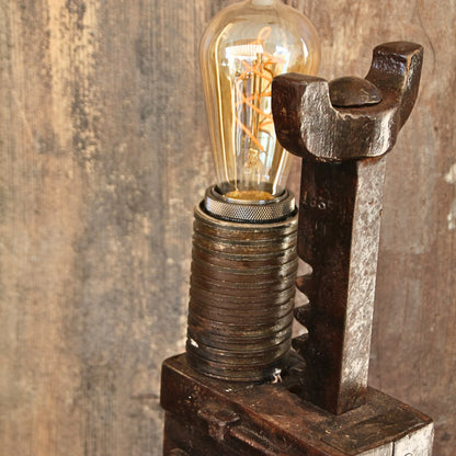 Zoom sur le haut de la lampe artisanale avec l'ampoule – Éclairage chaleureux et design original.