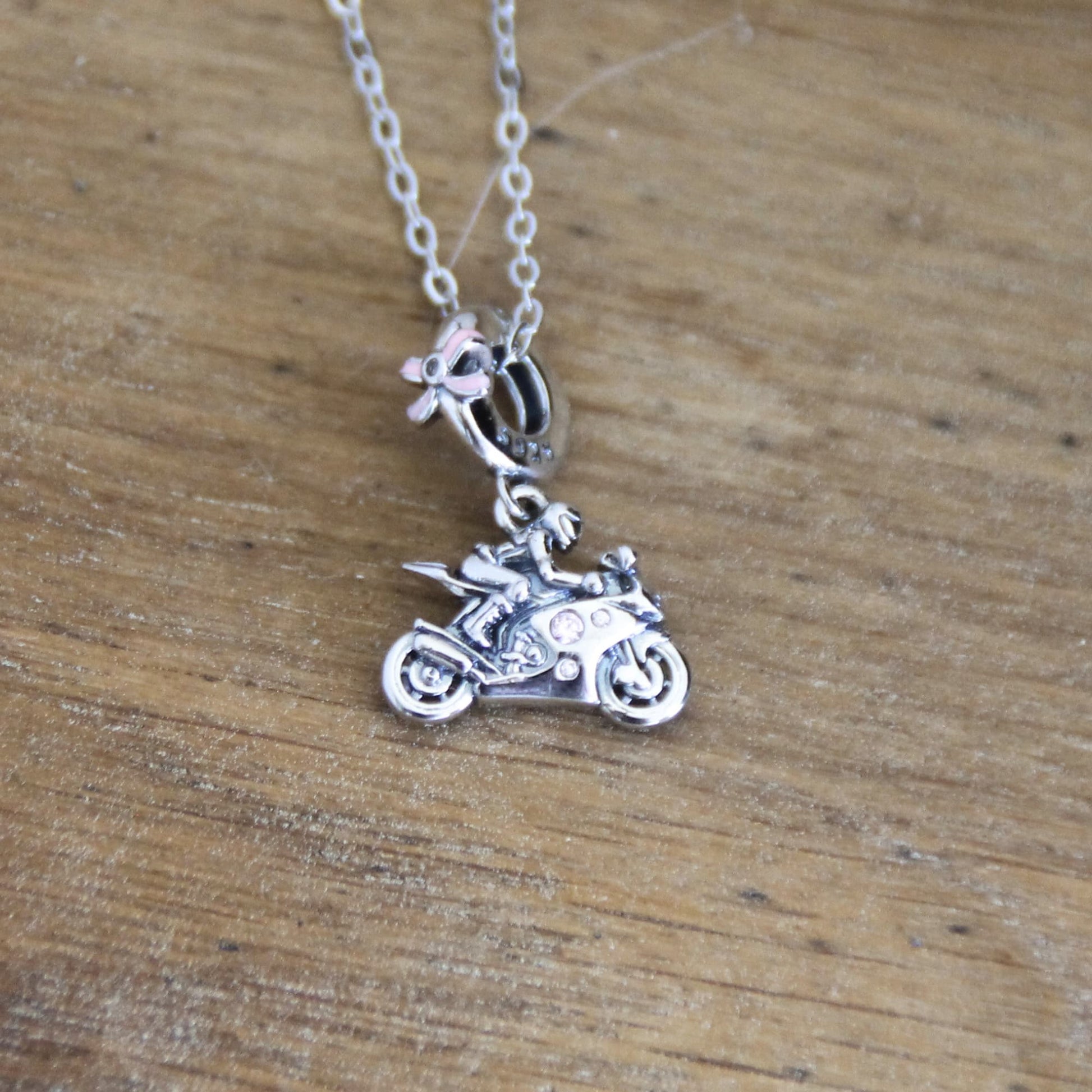 Collier charm argent 925 pendentif motarde sur sa moto noeud et zircons roses