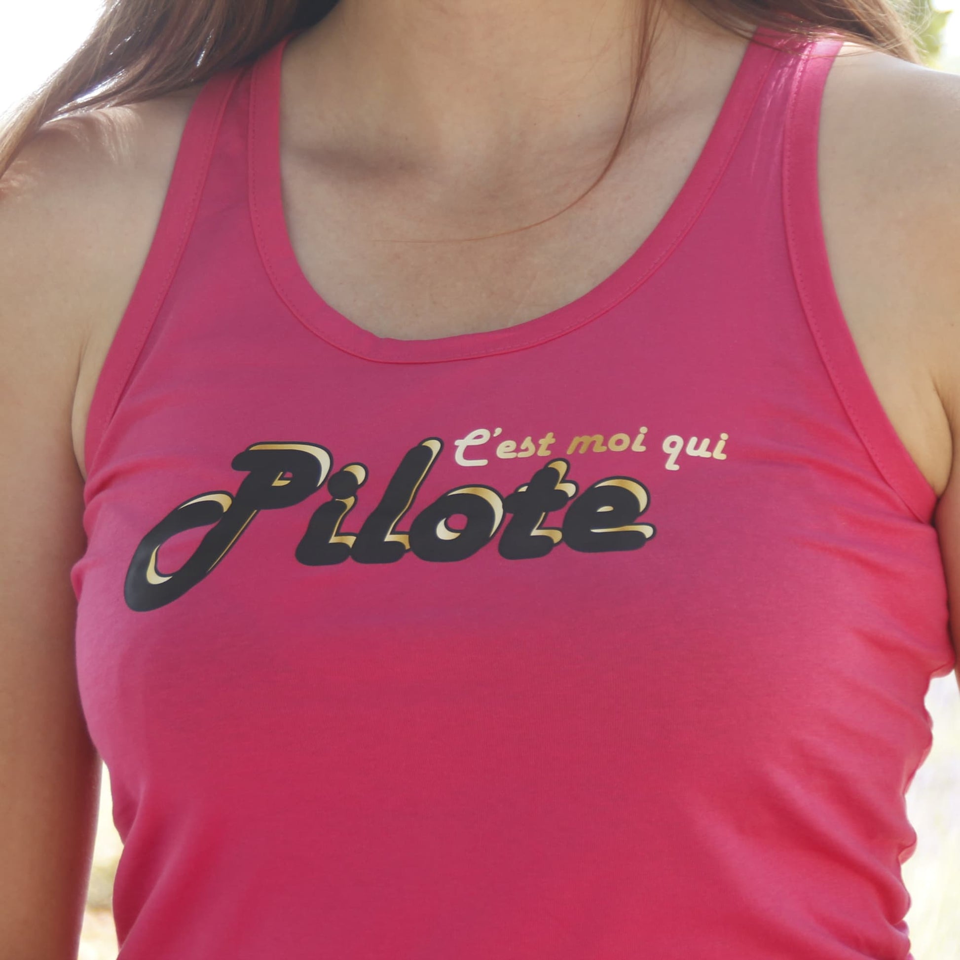 Zoom sur la phrase "c'est moi qui pilote" du débardeur rose pour femme motarde