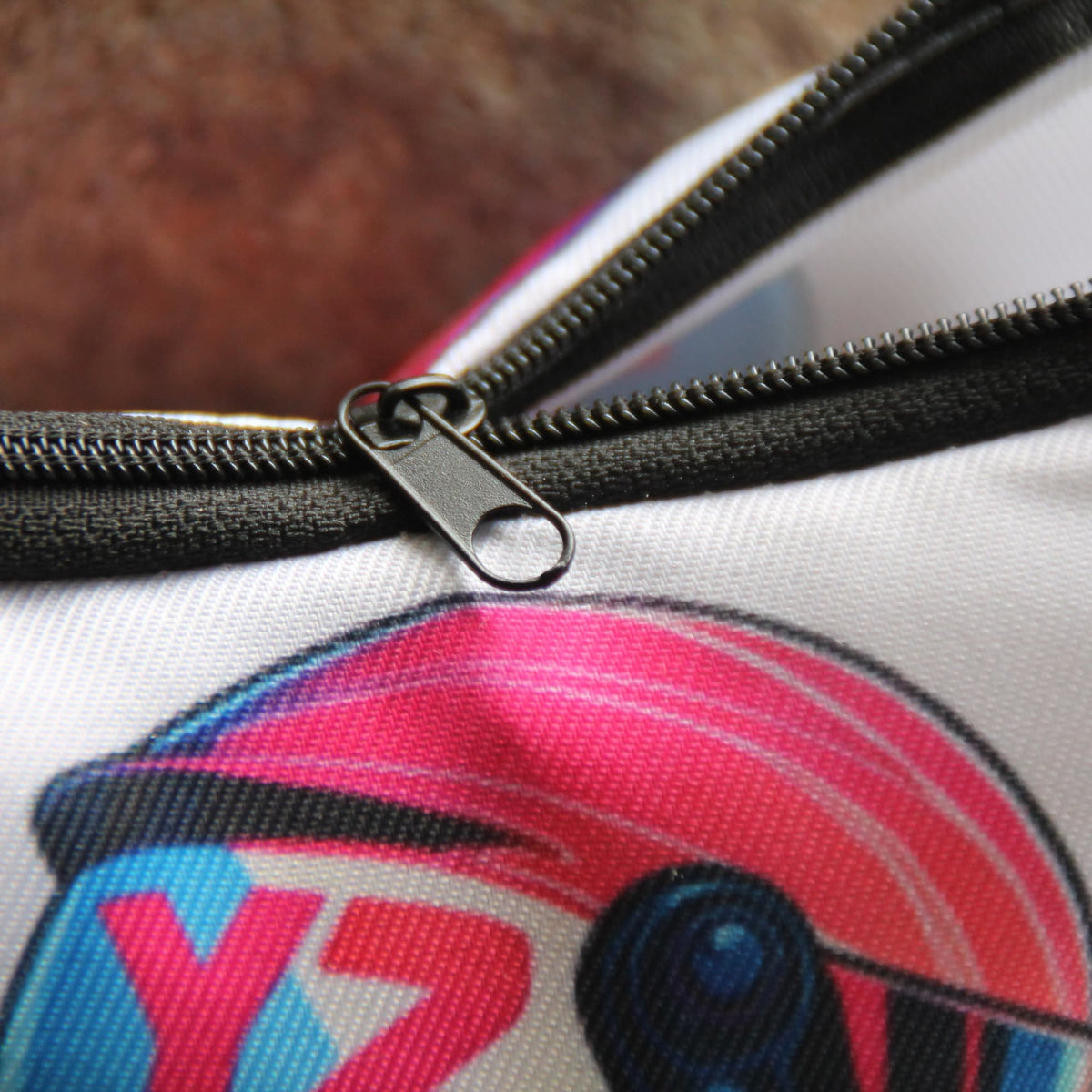 Zoom sur la fermeture éclair et le tissu de la pochette motarde avec casque rose