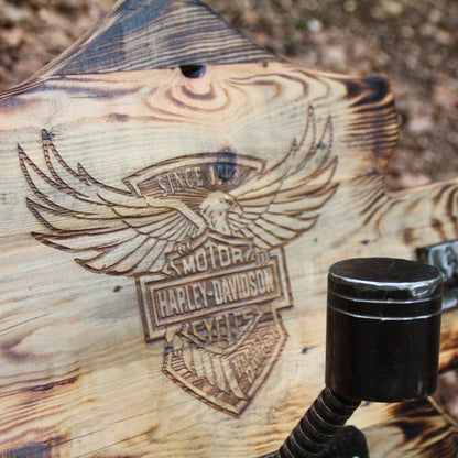 Gros plan gravure profonde logo Harley Davidson sur porte casque moto mural bois brûlé – détail relief saisissant et effet old-school biker artisanal