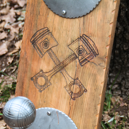 Zoom sur gravure duo de pistons au centre du porte casque moto mural "Born to Ride" – détail mécanique authentique handmade