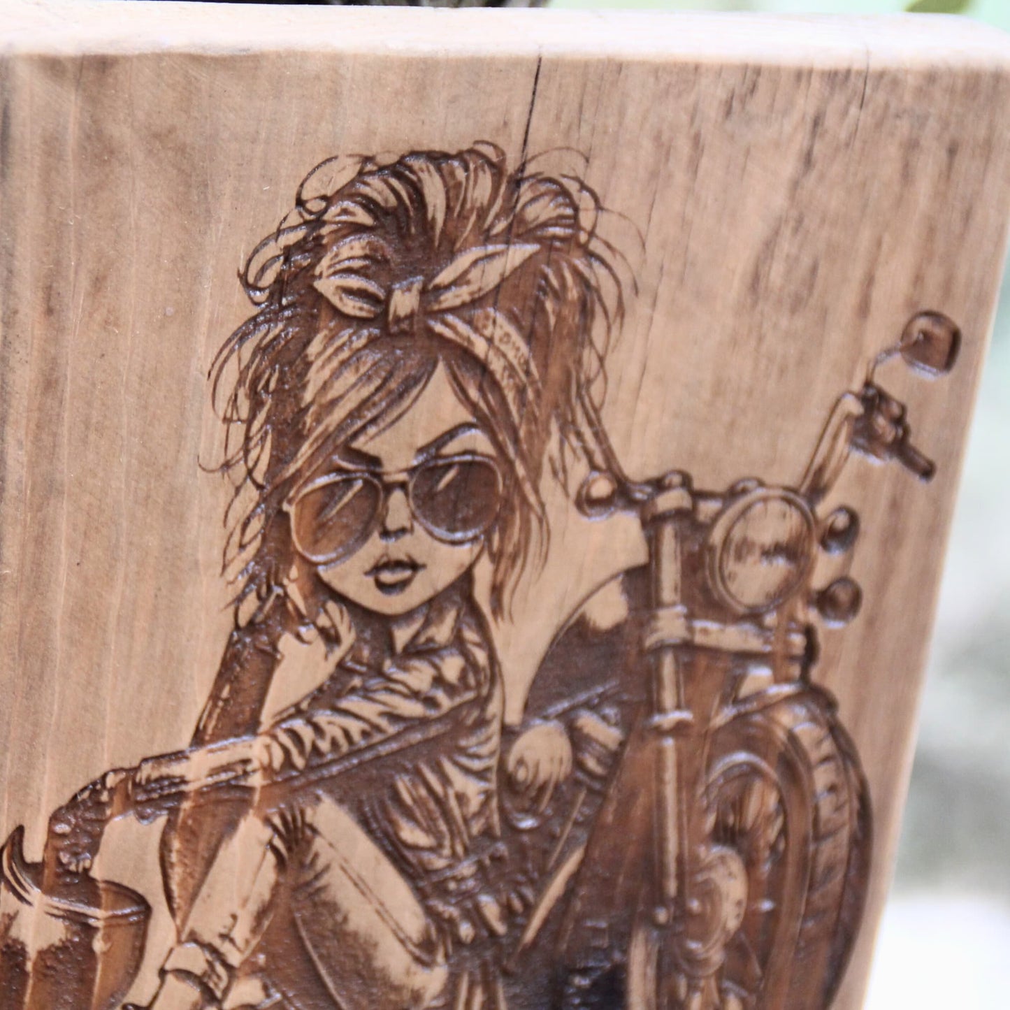 zoom sur la gravure du Tableau artisanal en bois gravé d'une motarde caricaturale